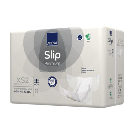 Abena Slip Premium XS 2 ist eine anatomisch geformte Einweg-Inkontinenzwindel in der Farbe Weiß. Im Vordergrund sind die elastischen Bündchen und die breite Klebefläche deutlich sichtbar, die für einen sicheren Sitz sorgen. Das Material sieht weich und atmungsaktiv aus, während die senkrechten Saugkanäle für eine optimale Flüssigkeitsaufnahme konzipiert sind. Auf dem Produkt sind wichtige Informationen und Größenangaben aufgebracht, was die Benutzerfreundlichkeit betont.