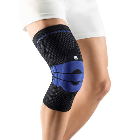 Schwarze Bauerfeind GenuTrain Kniebandage für gezielte Unterstützung und Stabilität des Knies. Die Bandage ist aus atmungsaktivem, elastischem Material gefertigt, das sich eng an das Bein anschmiegt und eine optimale Bewegungsfreiheit bietet. An der Innenseite ist eine integrierte Gelpolsterung sichtbar, die gezielt Druck auf das Gewebe ausübt und Schmerzen lindert.