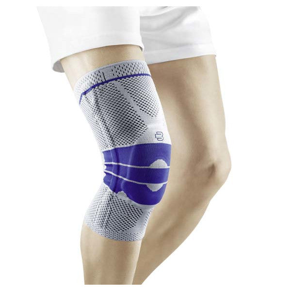 Kniebandage von Bauerfeind im Bild, Modell GenuTrain. Die Bandage ist in Titanfarbe, aus leichtem, atmungsaktivem Material und bietet eine anatomische Passform. Sie umschließt das Knie und unterstützt die Kniescheibe, die durch eine spezielle Gummikonstruktion verstärkt ist. An den Seiten der Bandage sind stabilisierende Elemente sichtbar, die zusätzliche Unterstützung bieten. Der obere und untere Rand sind elastisch und sorgen für einen sicheren Sitz ohne Verrutschen.