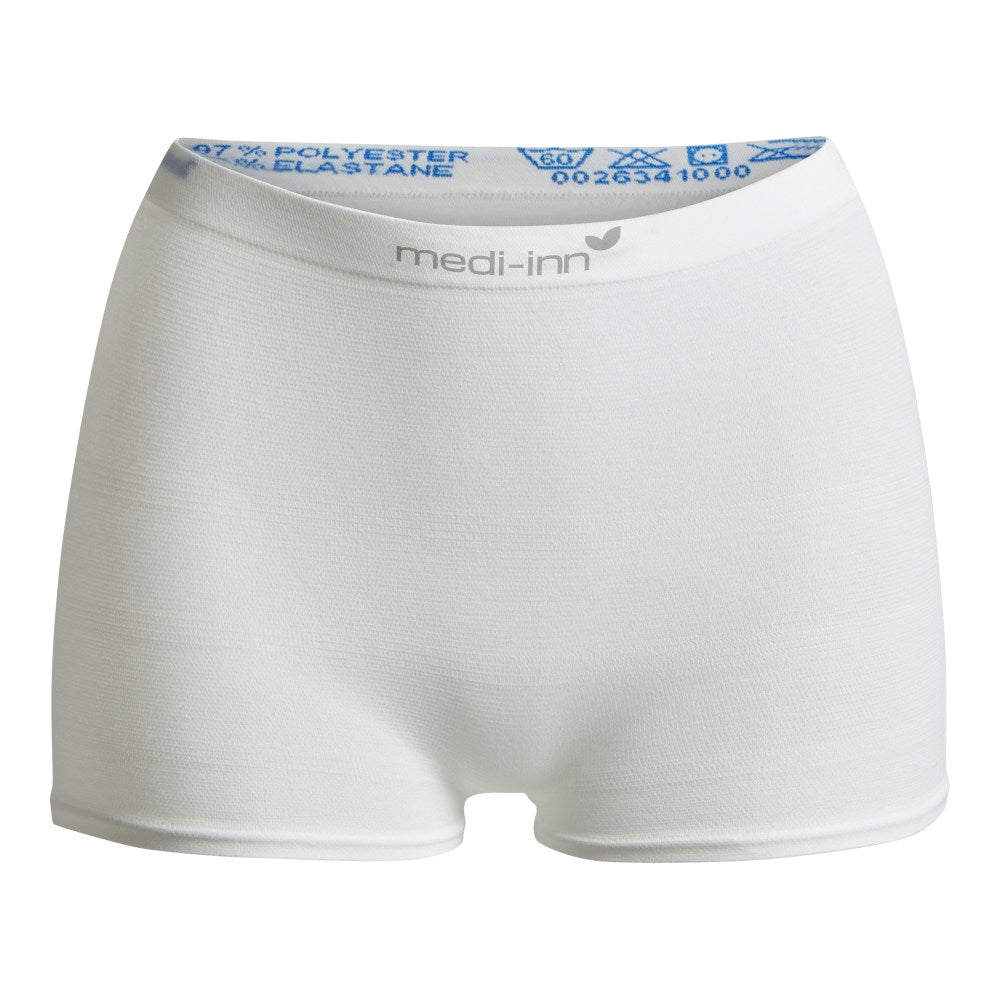 Weiße Fixierhose der Marke "medi-inn" in Größe M. Die Hose besteht aus einem elastischen Polyester-Elasthan-Gemisch und dient zur sicheren Fixierung von Inkontinenzmaterial. Das Produkt hat einen breiten, elastischen Bund mit Aufdruck der Materialzusammensetzung und Pflegehinweisen.