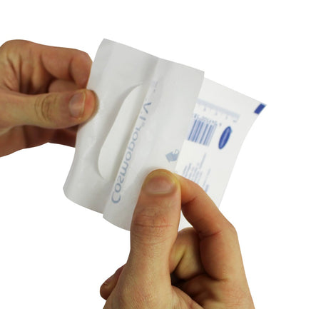 Hände beim Öffnen der sterilen Einzelverpackung eines Cosmopor® I.V. Pflasters.