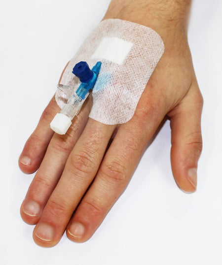 Cosmopor® I.V. Pflaster fixiert einen venösen Zugang auf dem Handrücken einer Person.