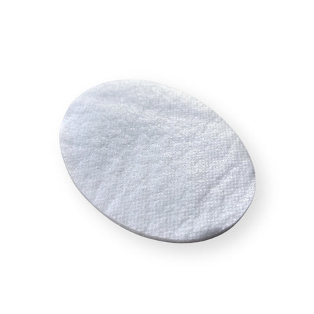 Weiße ovale Augenkompresse aus Vlies in schräger Ansicht auf hellem Hintergrund.
