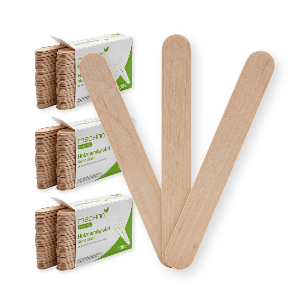 Frontalansicht von drei gefächerten Medi-Inn Mundspatel aus Holz neben der Verpackung von 500 Stück.